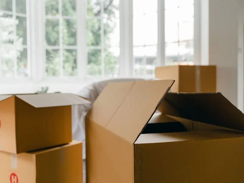 Packed cardboard boxes ready to go in a bright flat with big windows